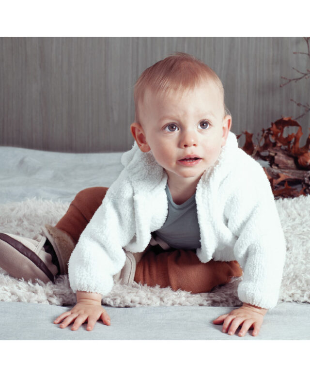 Luke wears white fleece by Angel Dear, Tiny Giants sweatpants, Saint Haven one-piece and Robeez boots.