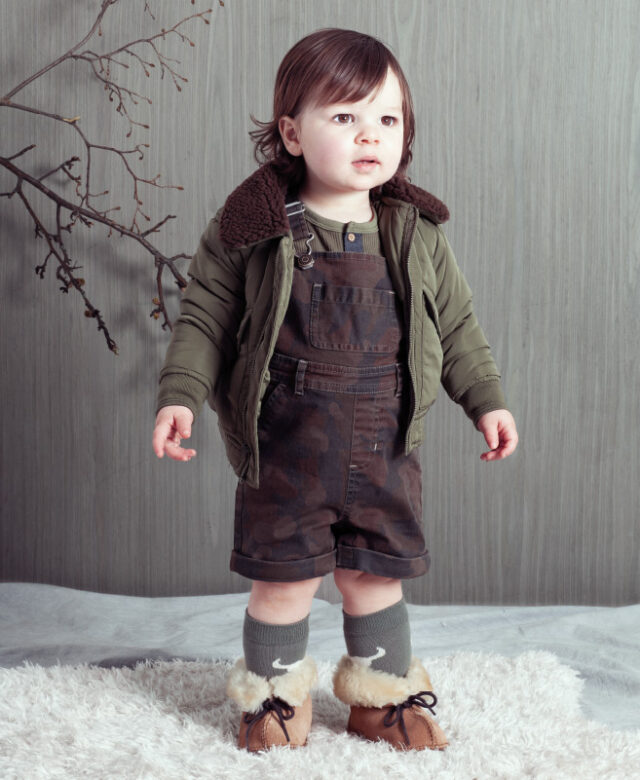 Niall wears Hudson Kids bomber jacket and Henley top, Blu & Blue camo shortalls, Booso socks and Bearpaw boots.
