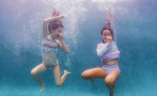 From left: Maddie wears Floatimini ruffle bikini; Marissa wears RuffleButts long-sleeved swim top and bottom.