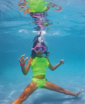 Opposite: Sophie wears Planet Sea neon two-piece,   goggles by Bling2O and bracelet by Henny and Coco.