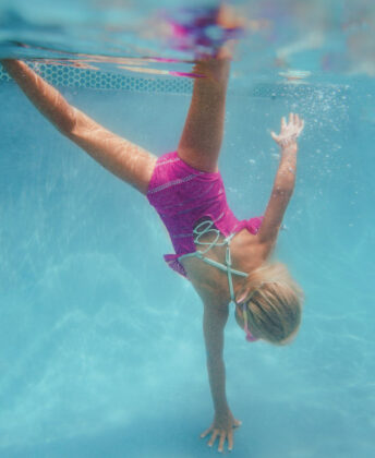 Aurora wears Coral & Reef Beachwear one-piece.
