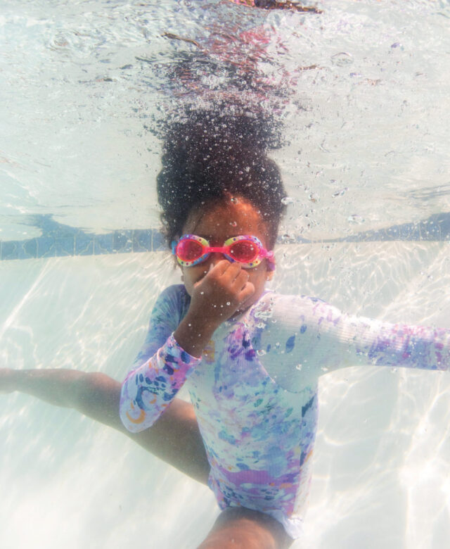 Zion wears Saint Maddox one-piece and Mud Pie goggles.