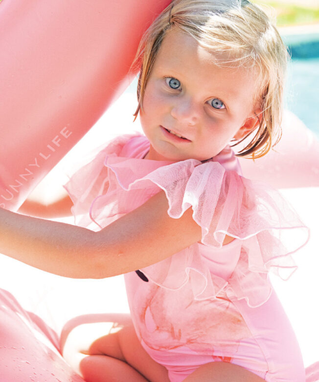 Eloise wears Shade Critters flamingo one-piece