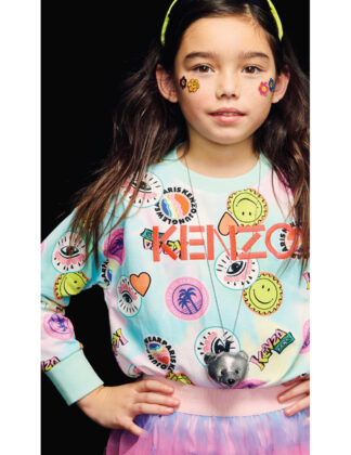 Isabella wears Caffe D’orzo necklace, Molo sunglasses worn on head, Kenzo sweatshirt and Deux Par Deux rainbow tulle skirt.