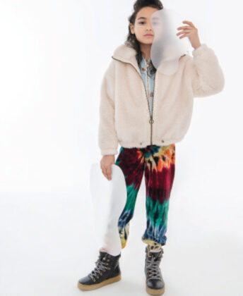 Myami wears For All Seasons white faux fur zip-up jacket, Lola + the Boys blue sequin bomber, Molo tie-dye velvet joggers and Young Soles black shearling-lined boots.