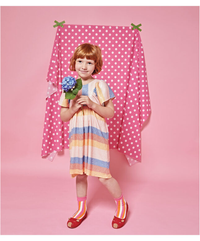 Greta wears 
Mademoiselle à Soho dress, Fun Socks striped socks and L’Amour Shoes flats. 

Photographed in Los Angeles, California.