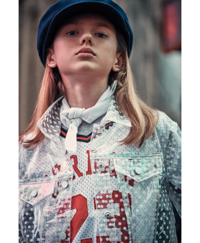 Carly wears Little Lids hat, 
vintage scarf, Nununu long-sleeve shirt, Jordan jersey, Tractr transparent jacket, Tommy Hilfiger pants and stylist’s own umbrella.