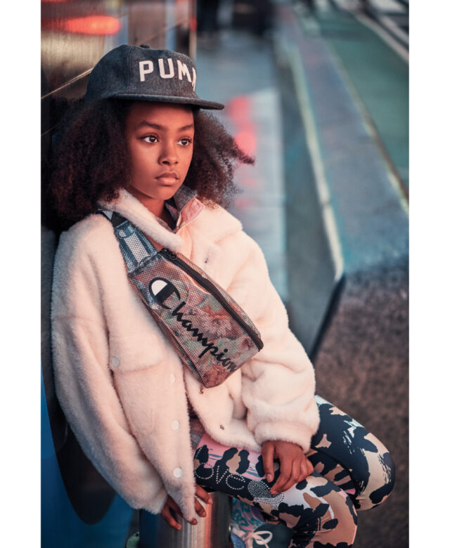 Jaelise wears Puma cap, Tractr pink coat, Bella Dahl plaid top, Big Love leggings and Champion fanny pack.