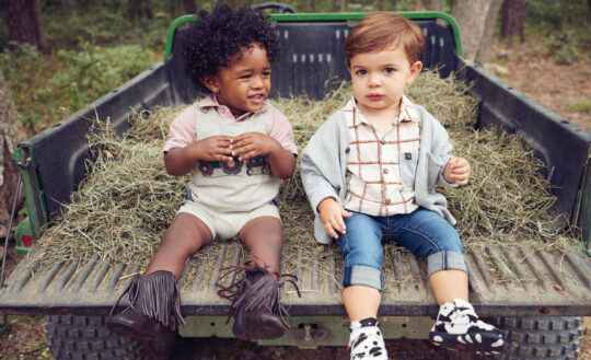 Carter wears Boboli polo, Mud Pie one-piece and soft-soled boots  by Nomandino; John wears sweater, shirt and jeans by Aimama with Twisted X cow print shoes.
