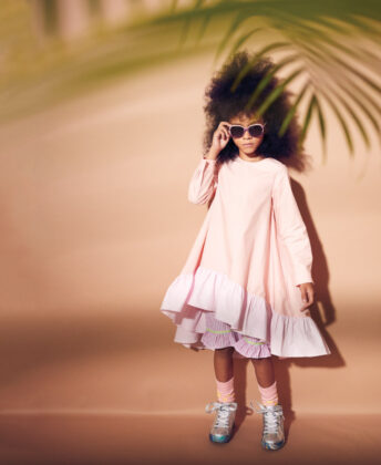 Charis wears Noon by Noor dress, Smocked Polka Dot striped shorts, socks by 
Fun Socks, Steve Madden 
metallic sneakers and 
Toucca Kids sunglasses.